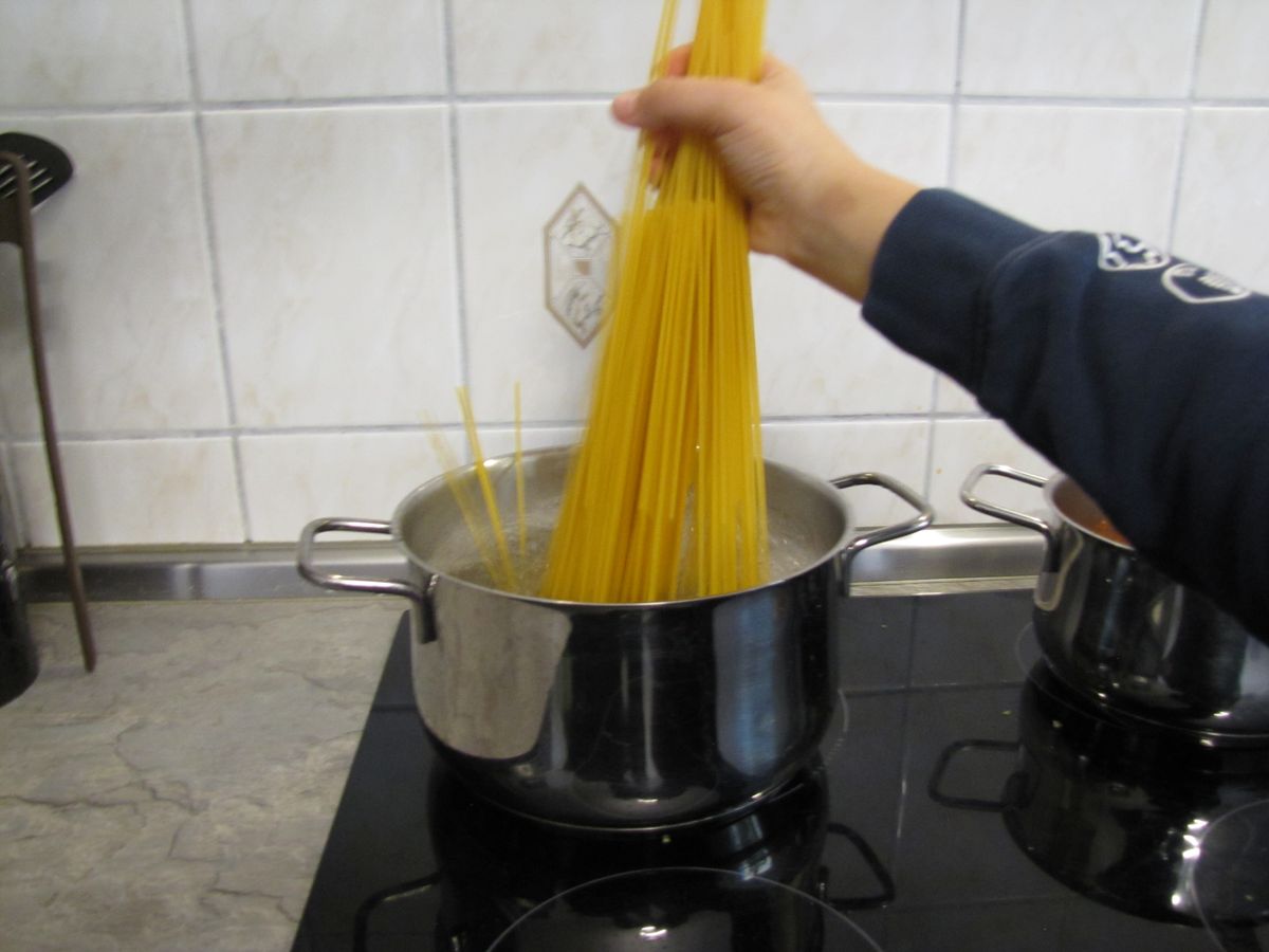 Spaghetti ins kochende Wasser geben